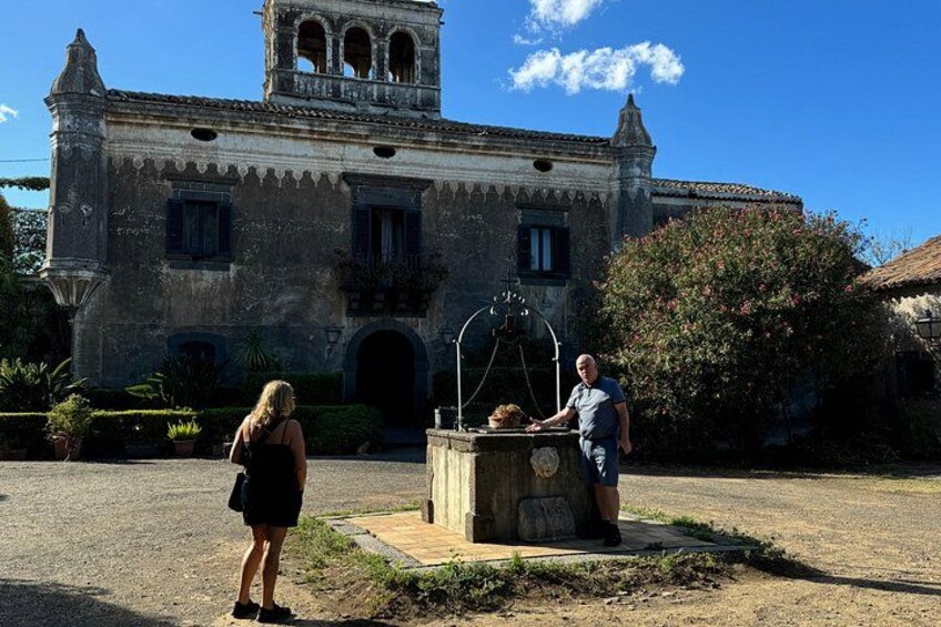 Un edificio histórico con una torre de campanas, una fuente y una persona de pie cerca de la fuente. 4