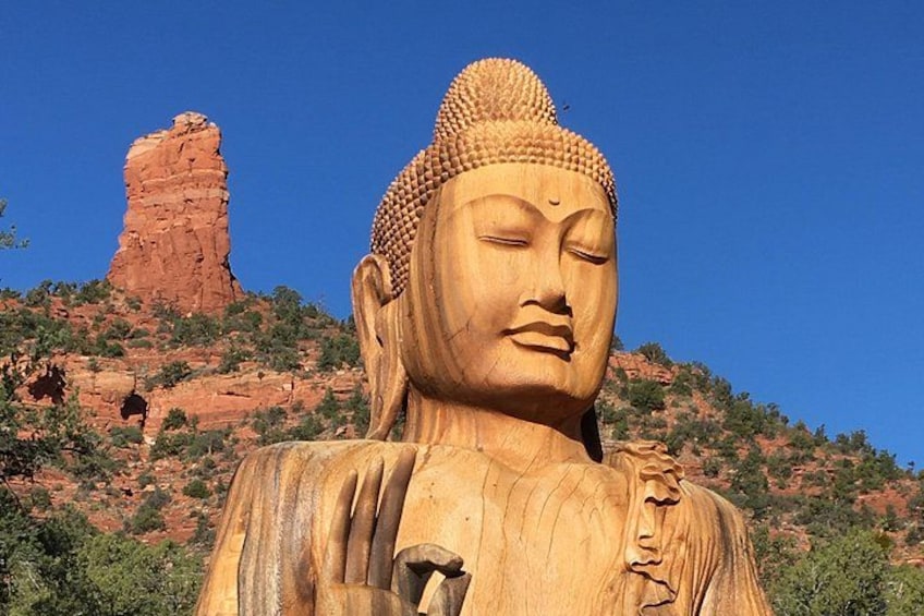 A large golden Buddha statue with a mountainous backdrop. 4