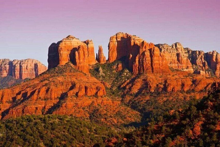 A desert landscape with red rock formations and sparse vegetation. 3