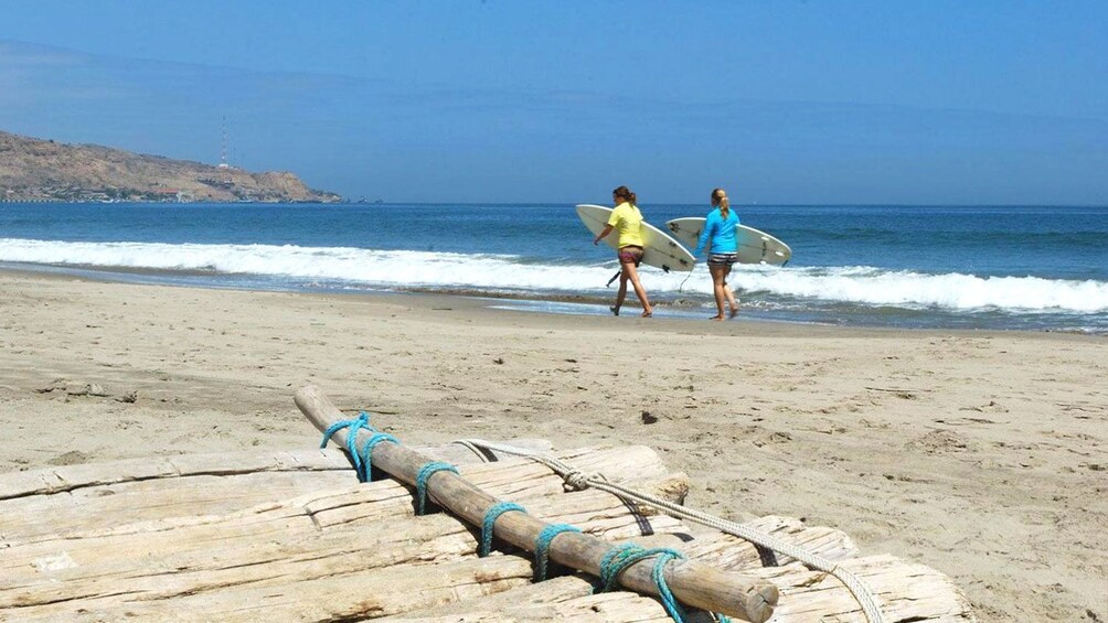 Surfers walking along the Tumbes Beaches