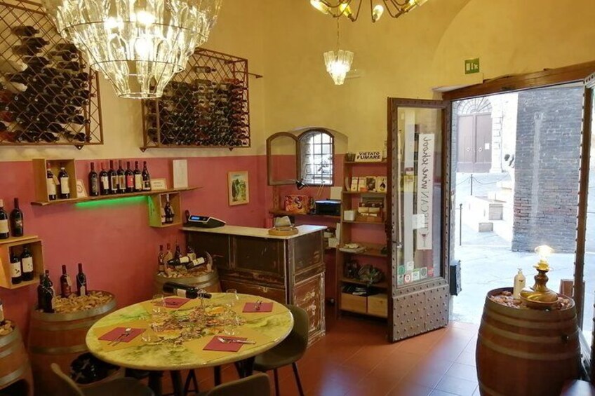 Un acogedor interior de restaurante con bodegas, una mesa redonda con sillas y un candelabro. 2