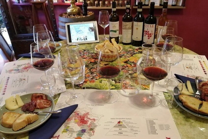 A wine tasting setup with glasses, bottles, and menus on a table. 3