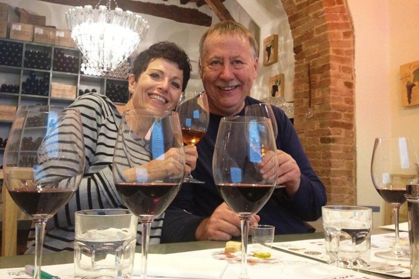 Dos personas sentadas en una mesa con copas de vino. 5