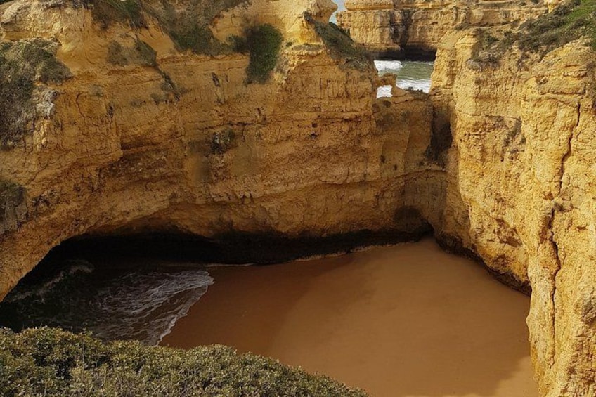 Un paisaje costero con una gran formación rocosa y un estrecho canal de agua. 4