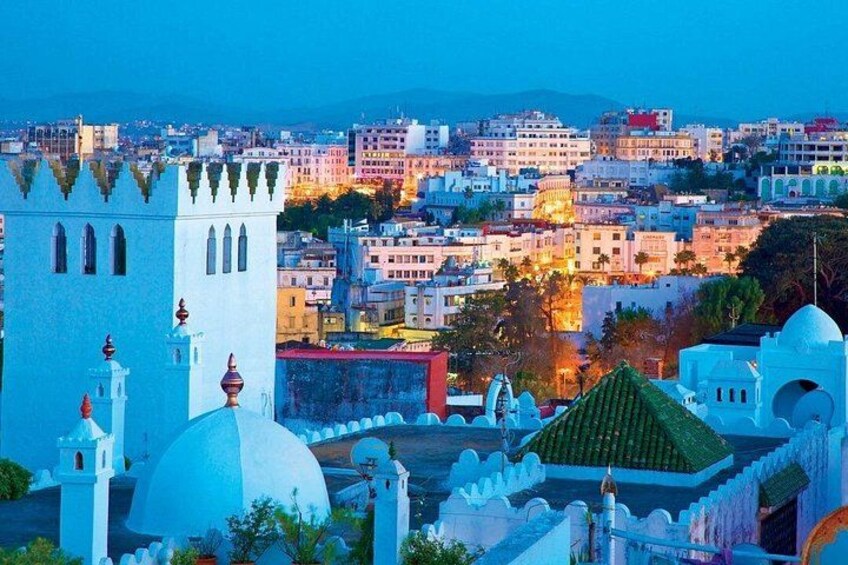 A coastal cityscape with historic architecture, including domed buildings and towers, under twilight sky. 4