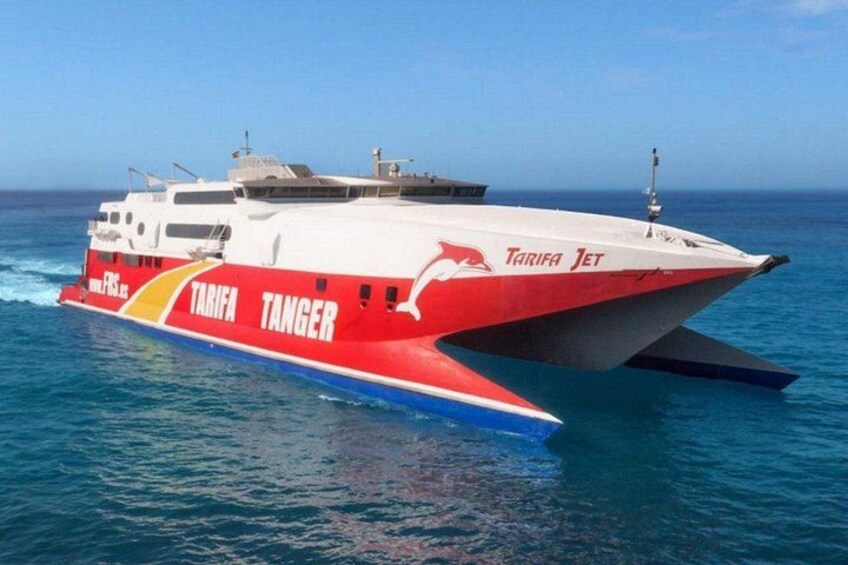 A red and white boat named Tarifa Jet on the water. 2