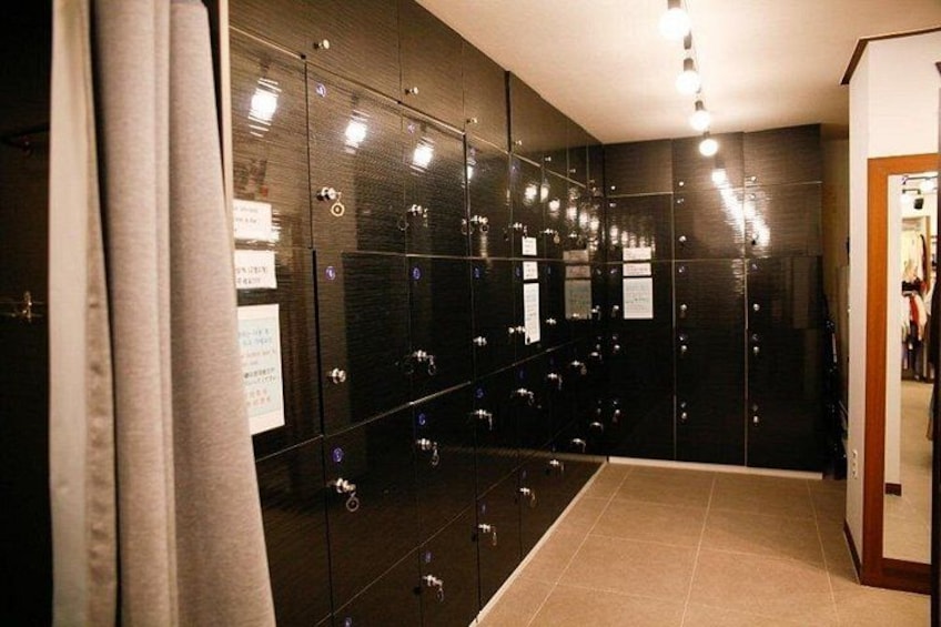 A modern bathroom with dark cabinets, a tiled floor, and a mirror. 2