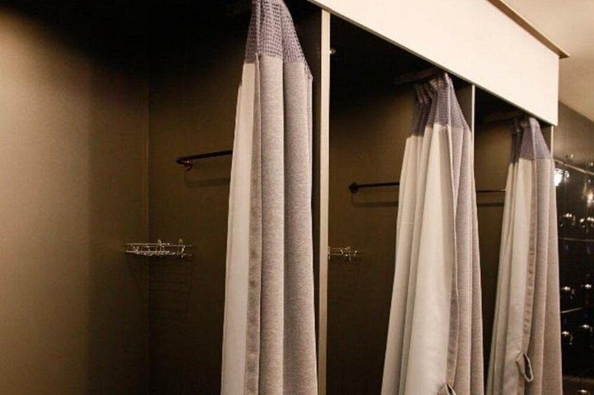 A bathroom with a shower curtain, towel rack, and a towel hanging on the wall. 3