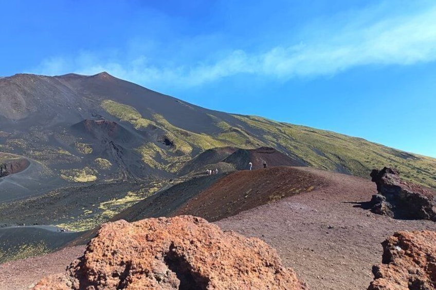 A volcanic landscape with a prominent mountain, rocky outcrops, and a clear sky. 4