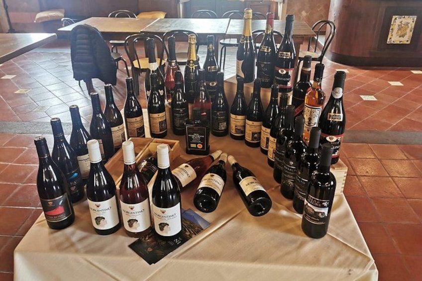 Una mesa con varias botellas de vino dispuestas sobre un mantel. 4