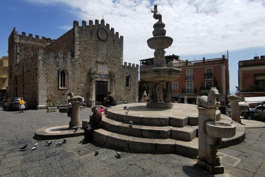 Un edificio de piedra histórico con una fuente en el centro. 3
