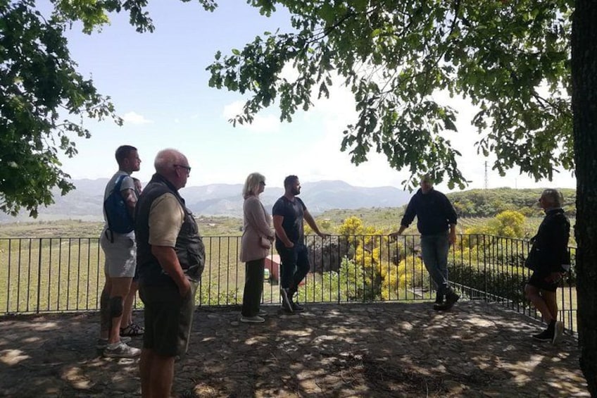 Un grupo de personas junto a una valla, con vistas a un paisaje montañoso a lo lejos. 2