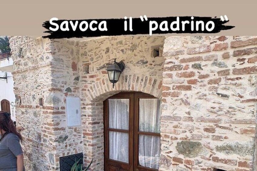 Un edificio de piedra con puerta y ventana de madera, y una lámpara en la pared. 5