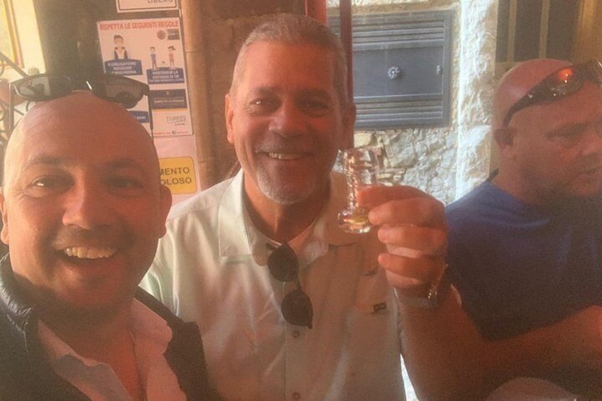 Tres personas en un bar, una sosteniendo una bebida. 2
