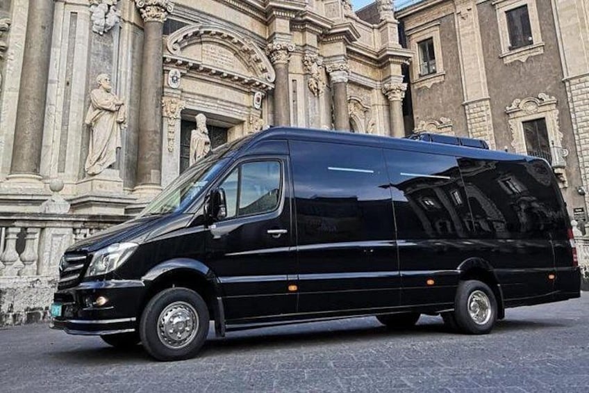A black van parked in front of a historic building with ornate architecture. 5