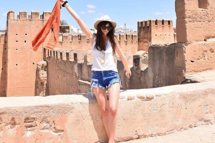 A person standing on a historical site with ancient fortifications in the background. 4