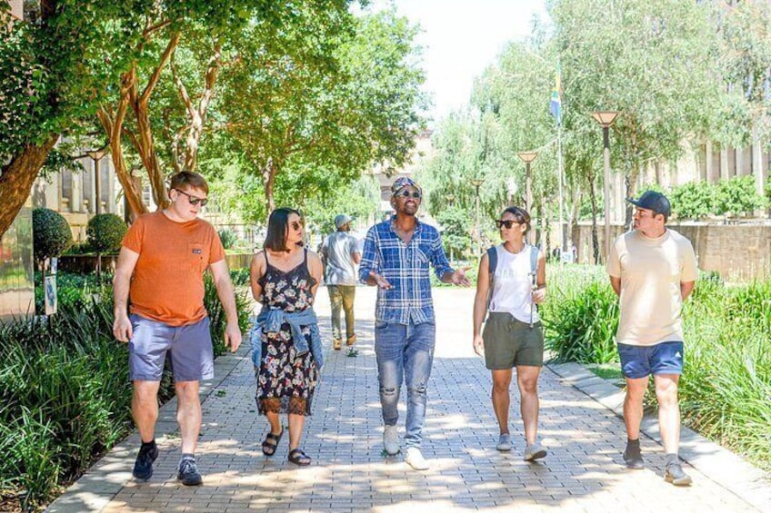 A group of people walking on a paved path surrounded by greenery and trees. 5