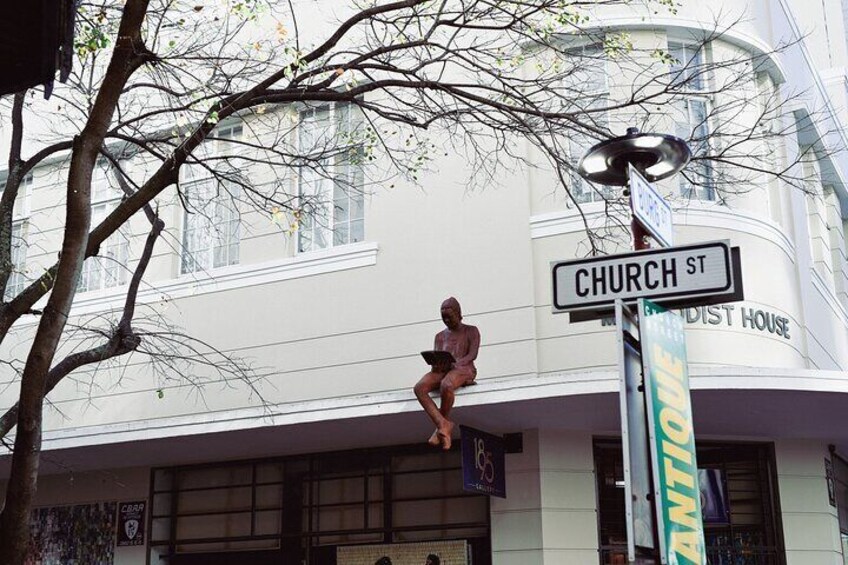 Un panneau de signalisation indiquant « CHURCH ST » et, au fond, un bâtiment portant l’inscription « MENDIST HOUSE ». 3