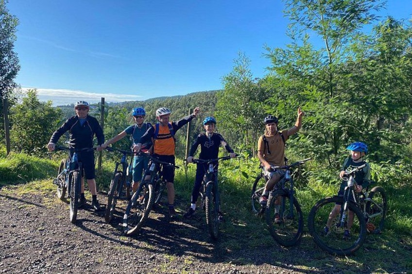 Un groupe de cyclistes sur un chemin de terre, entouré de verdure et de collines. 3