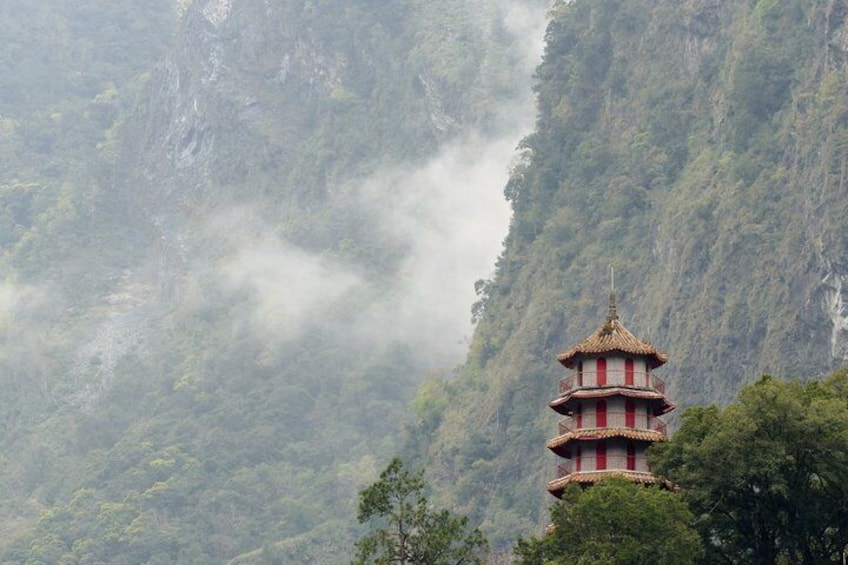 A multi-tiered pagoda in a mountainous area with dense forest. 3