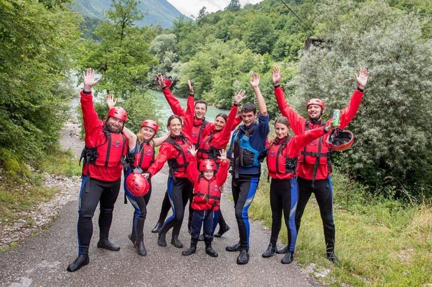 Un grupo de personas con chaquetas y cascos rojos en un sendero pavimentado rodeado de follaje. 4