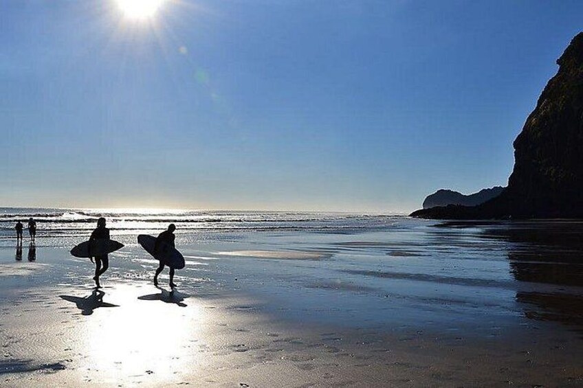 Une plage où l’on voit des gens se promener et porter des planches de surf. 3
