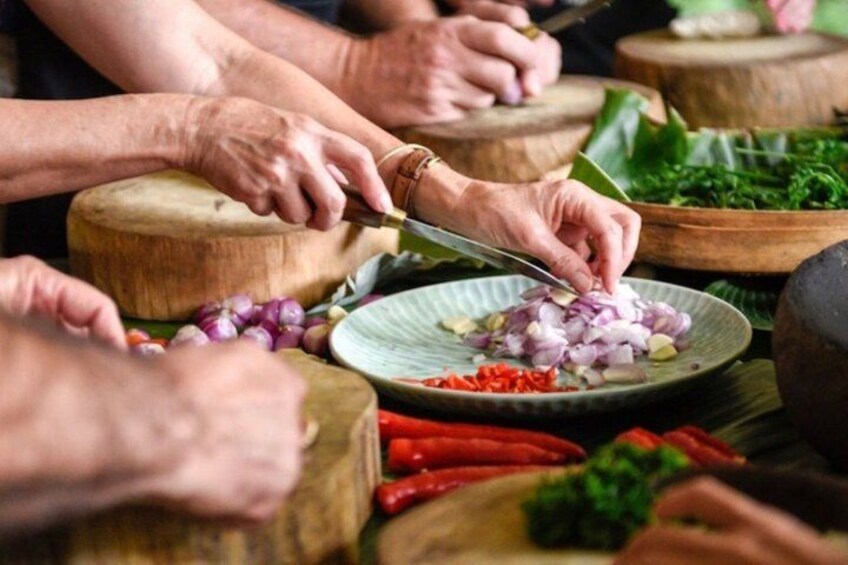 People chopping vegetables on wooden cutting boards. 4