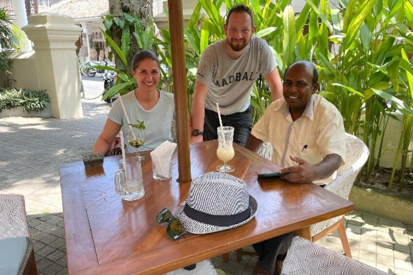 Tres personas sentadas en una mesa al aire libre, con bebidas y un sombrero. 5