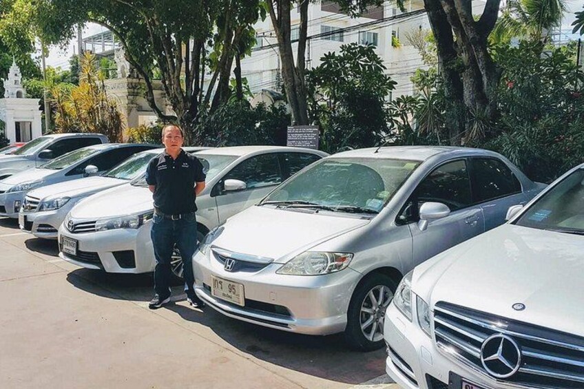 A man standing next to a row of parked cars, including a white Mercedes-Benz. 4