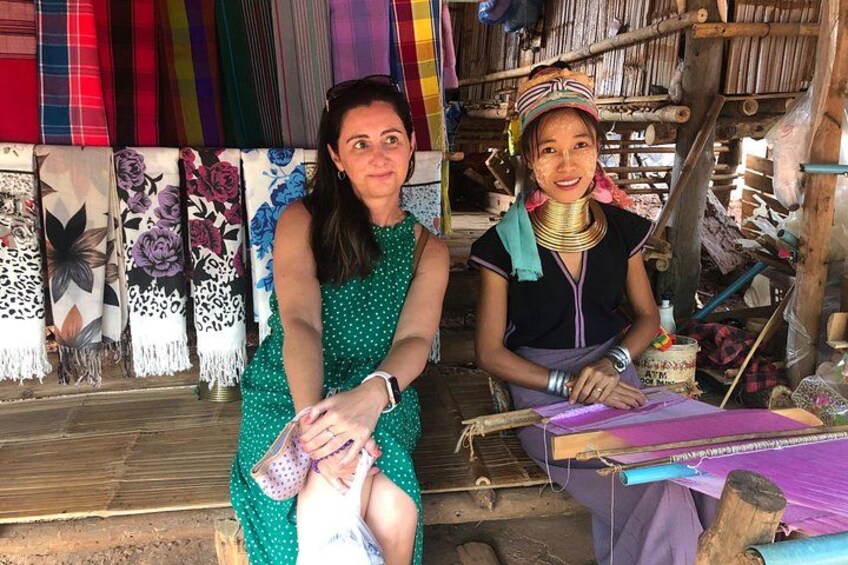 Two individuals in a workshop with colorful textiles and weaving tools. 2