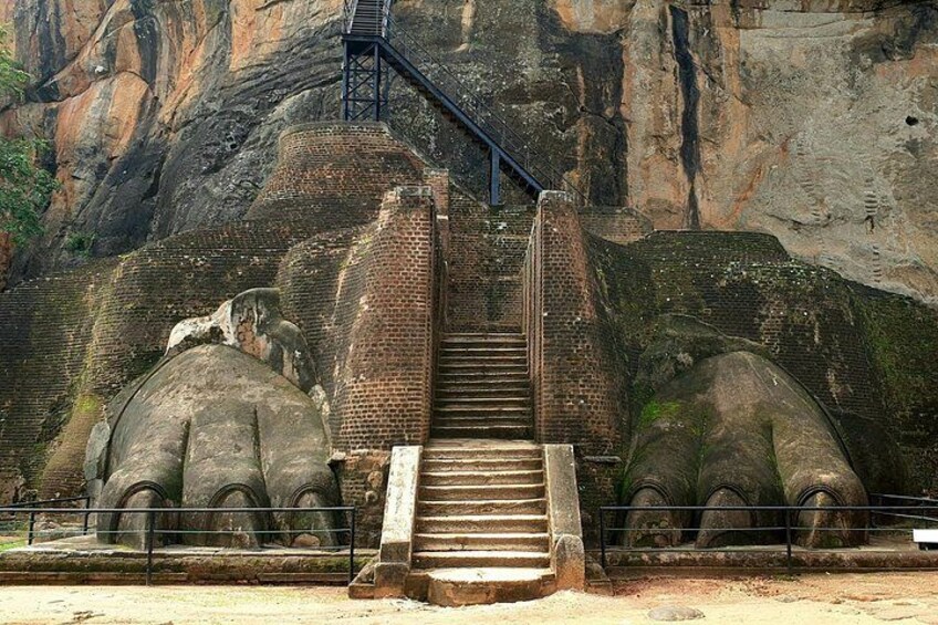 A staircase leading up to a rocky cliff with large elephant sculptures on either side. 5