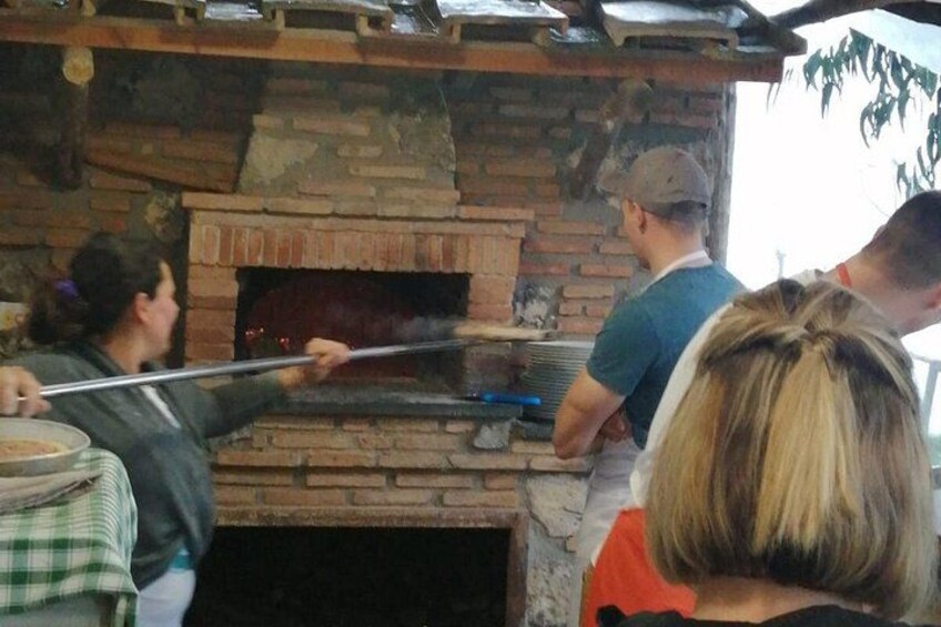 People using a brick oven for cooking. 2
