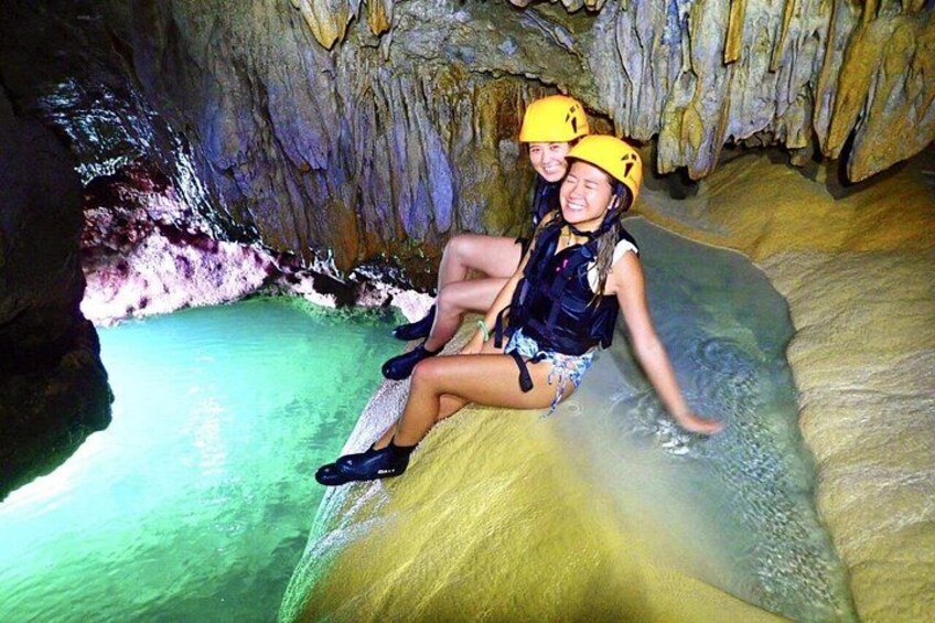 Two people in a cave with water formations. 4