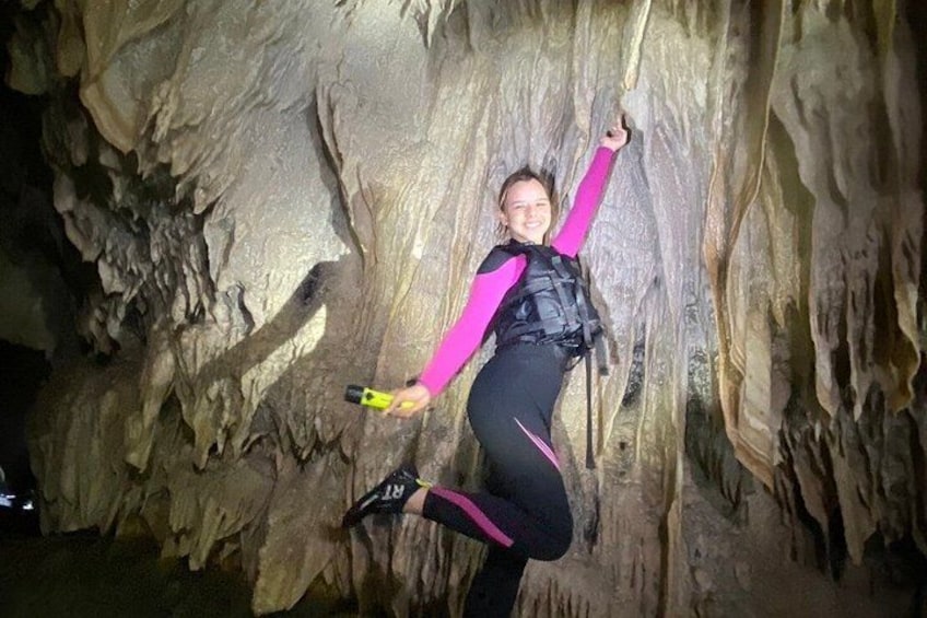 A person climbing a rock wall in a cave. 5