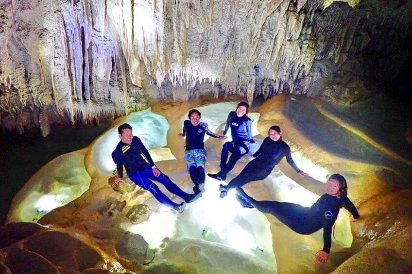 A group of people in a cave with stalactites. 5