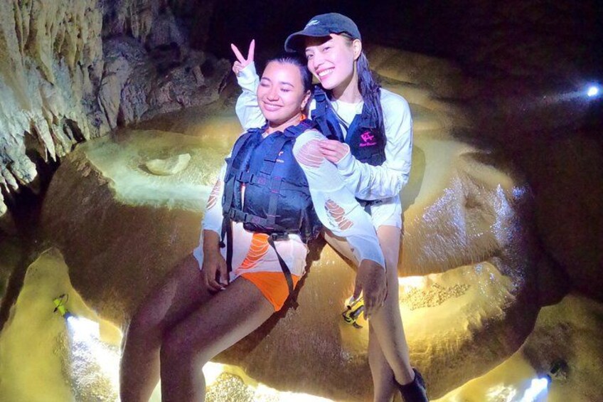 Two people in a cave with stalactites, wearing life jackets and a harness. 3
