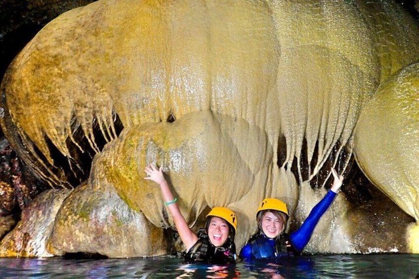 Two people in a cave with large stalactites. 1