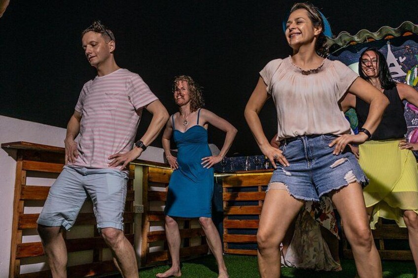 A group of people performing a dance routine outdoors at night. 5