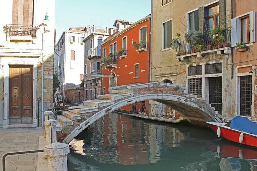 A canal with a bridge, buildings, and a boat. 3