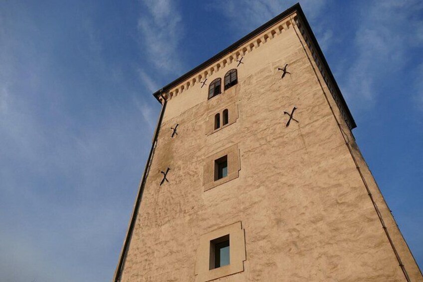 A tall, beige building with multiple windows and a clock on its facade. 5