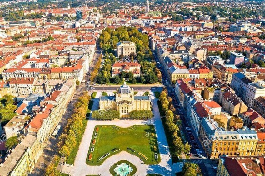 An aerial view of a city with a central square, surrounding buildings, and a prominent church. 1