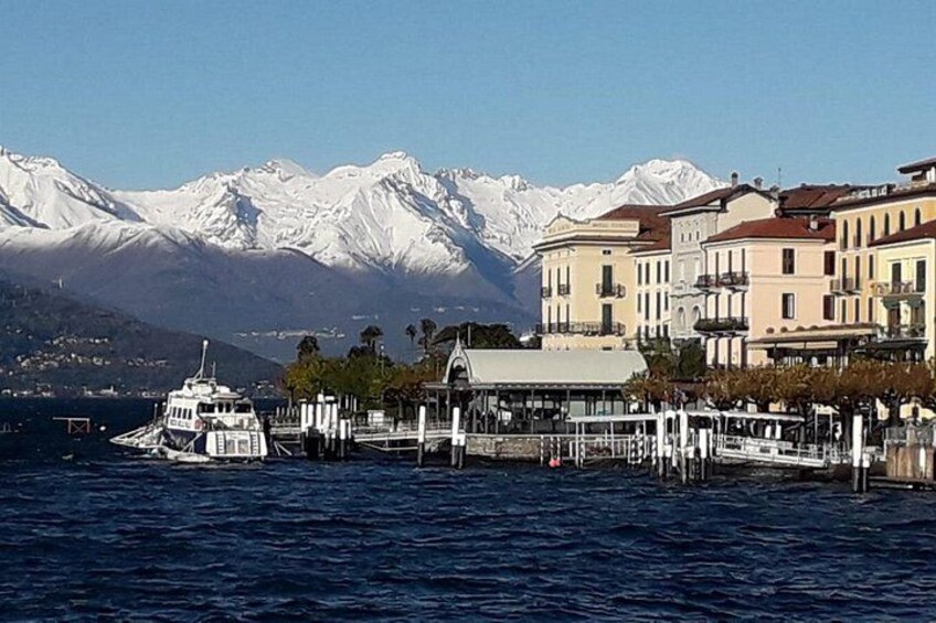 A boat docked at a pier with snow-capped mountains in the background. 3