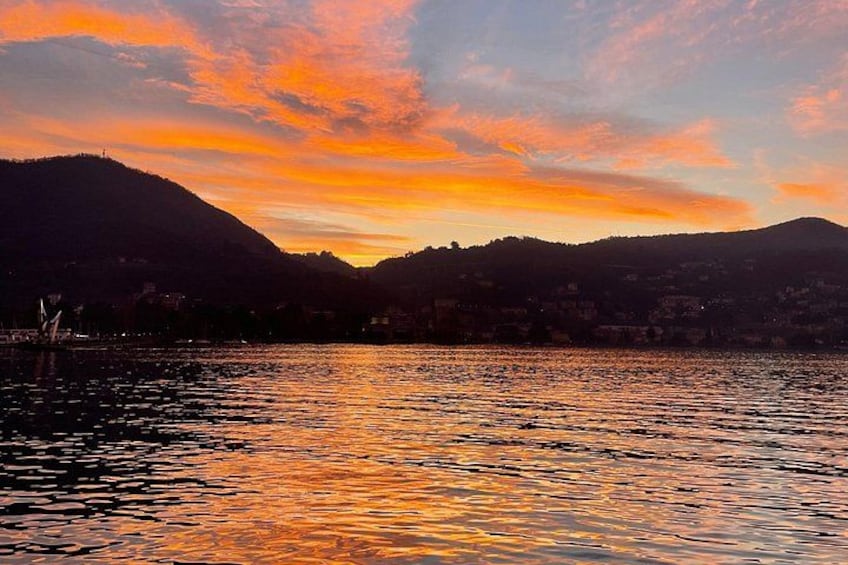 A sunset over a lake with mountains in the background. 4