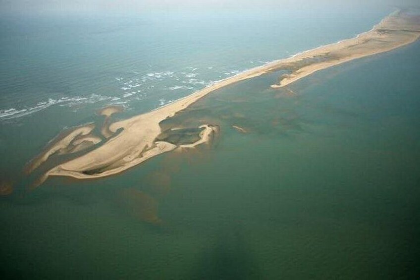 An aerial view of a coastal area with a sandy beach and clear water. 2