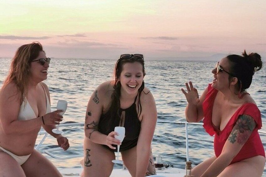 Three people on a boat with a sunset in the background. 1