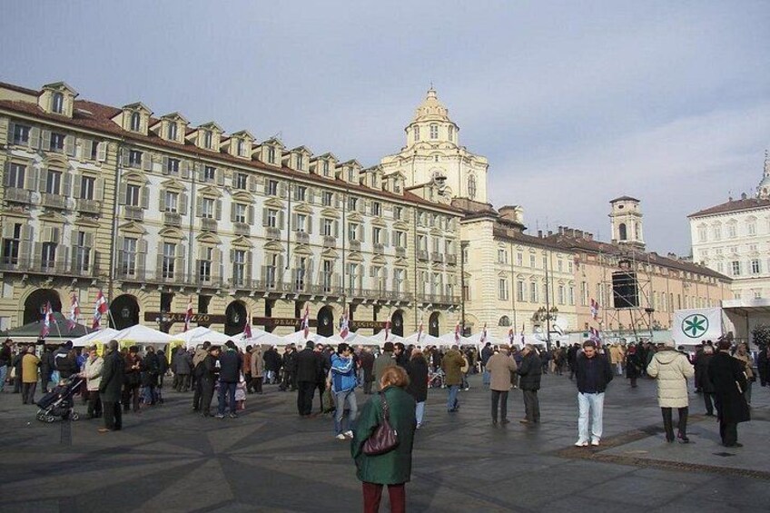 A large crowd in a square with historic buildings in the background. 5