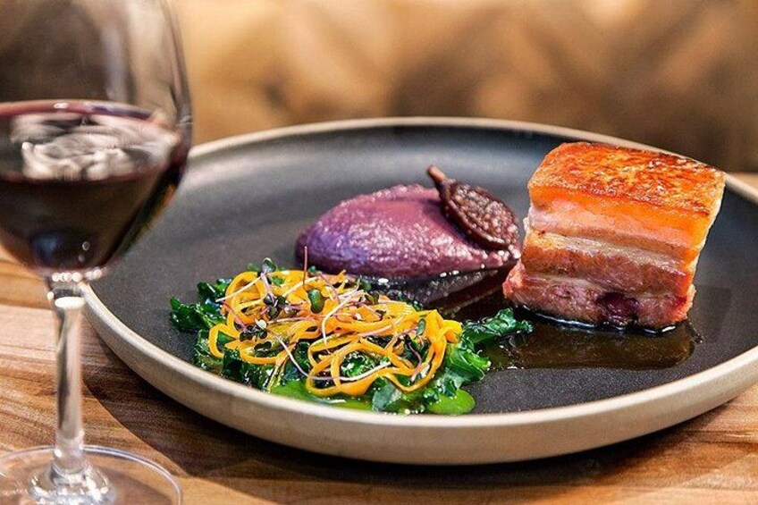 A plate of food with a glass of red wine. 2