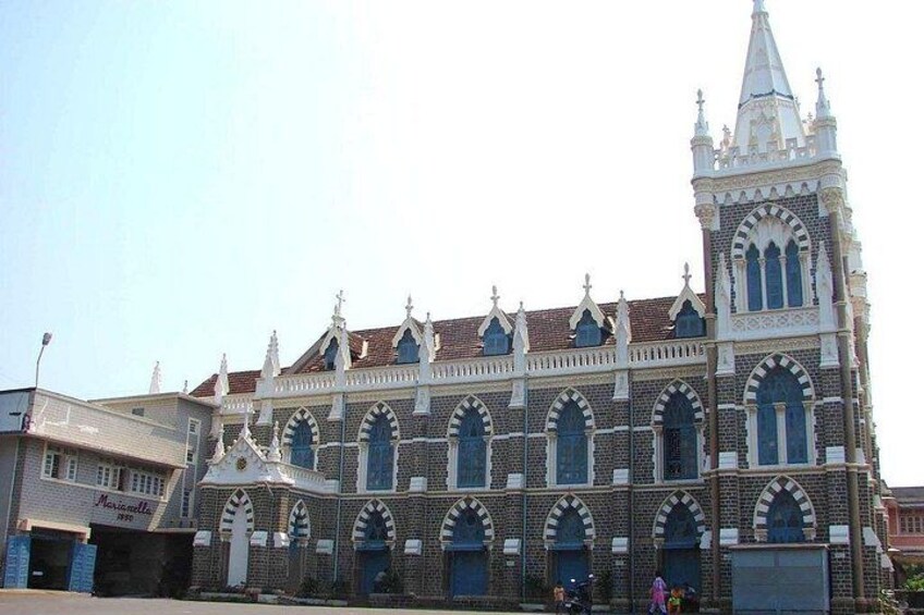 A large, ornate building with a clock tower, arched windows, and a pointed roof. 3