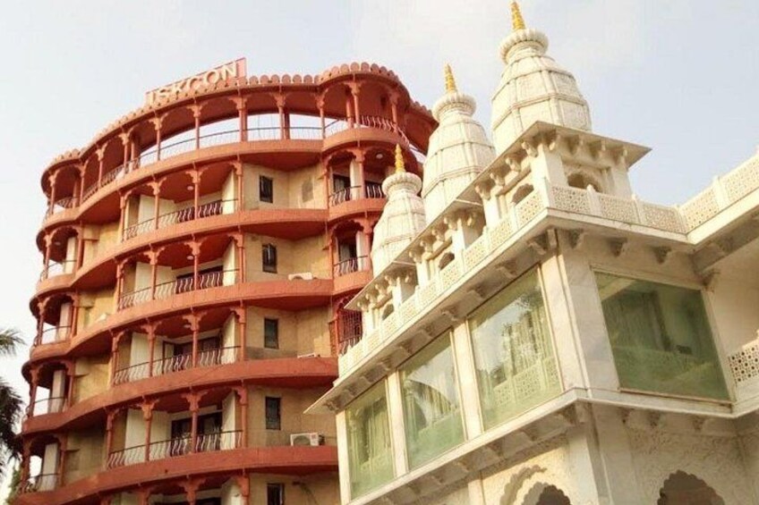 A multi-story building with balconies and a white structure with domes. 5