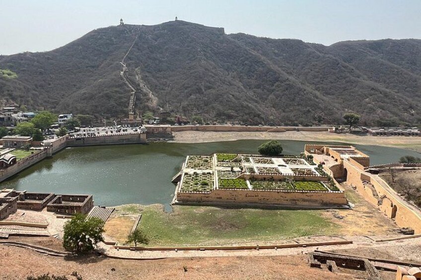 A large body of water surrounded by a fortified structure with a hilly landscape in the background. 2